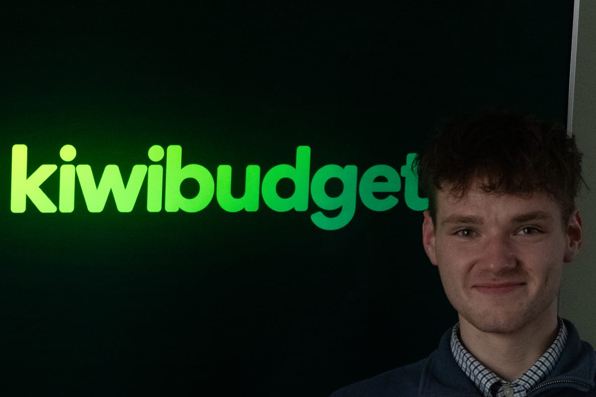 Jack Ridder beside the KiwiBudget logo in Invercargill, 2026